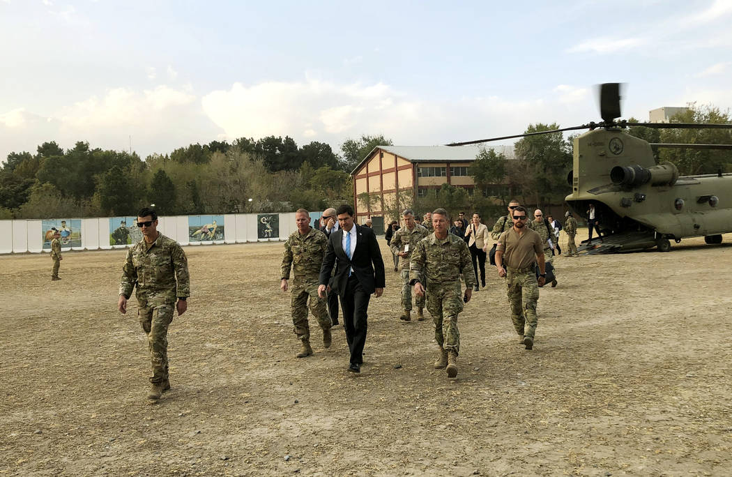 U.S. Defense Secretary Mark Esper, center, walks Gen. Scott Miller, right, chief of the U.S.-le ...