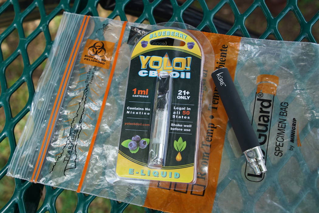 In a May 8, 2019, file photo, a Yolo! brand CBD oil vape cartridge sits alongside a vape pen on ...