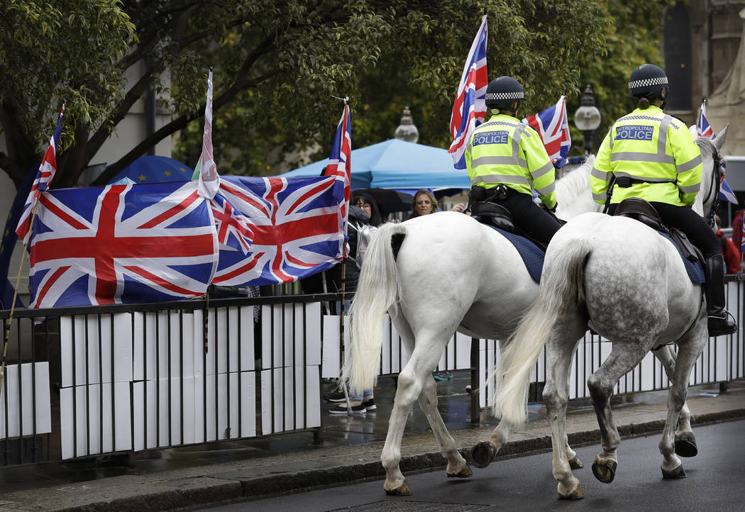 Police horses pass a confusion of flags and banners both pro and against Brexit, outside Parlia ...