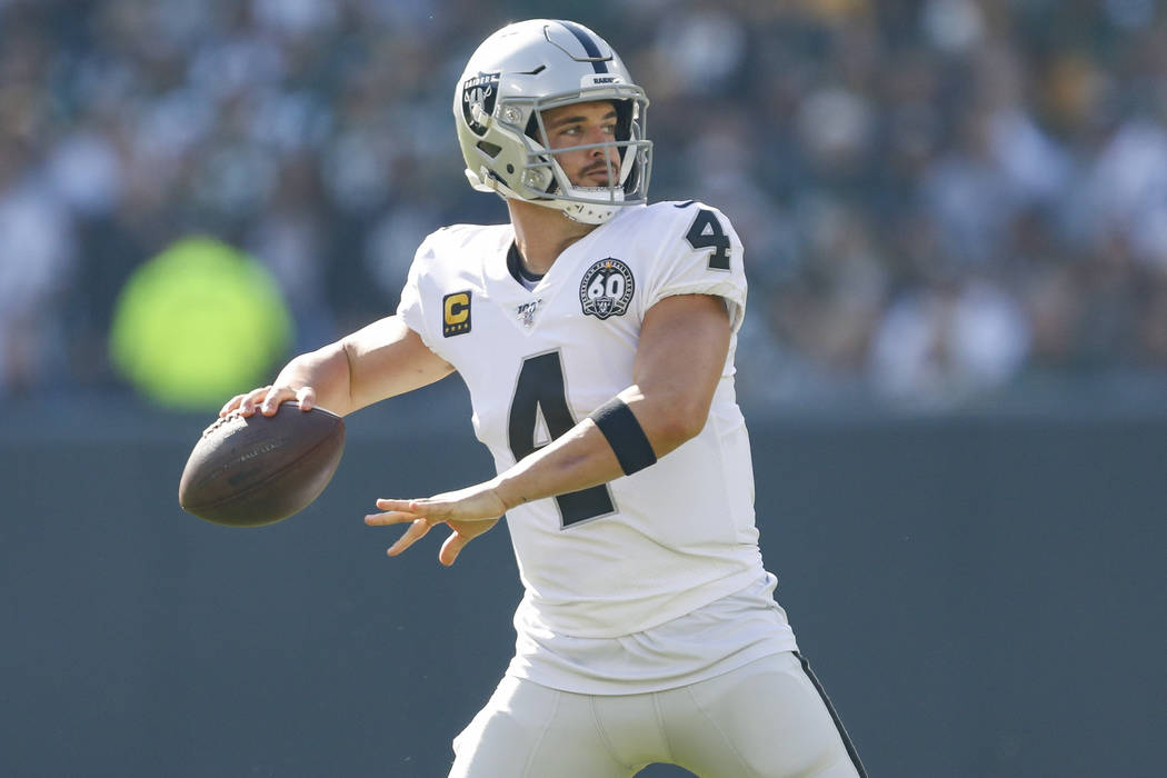 Oakland Raiders quarterback Derek Carr looks to pass during an NFL football game between the Gr ...