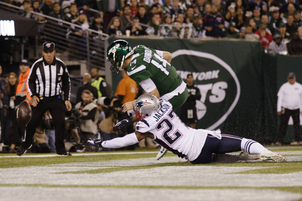 New England Patriots' J.C. Jackson (27) and New York Jets' Sam Darnold (14) fights for control ...