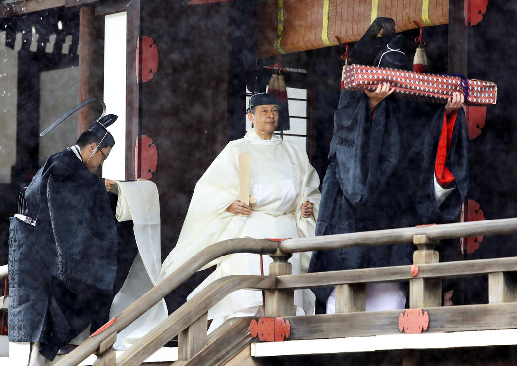 Japan's Emperor Naruhito, in a white robe, leaves after praying at “Kashikodokoro&#x201d ...