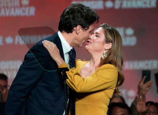Liberal leader Justin Trudeau and wife Sophie Gregoire Trudeau kiss as they celebrate on stage ...