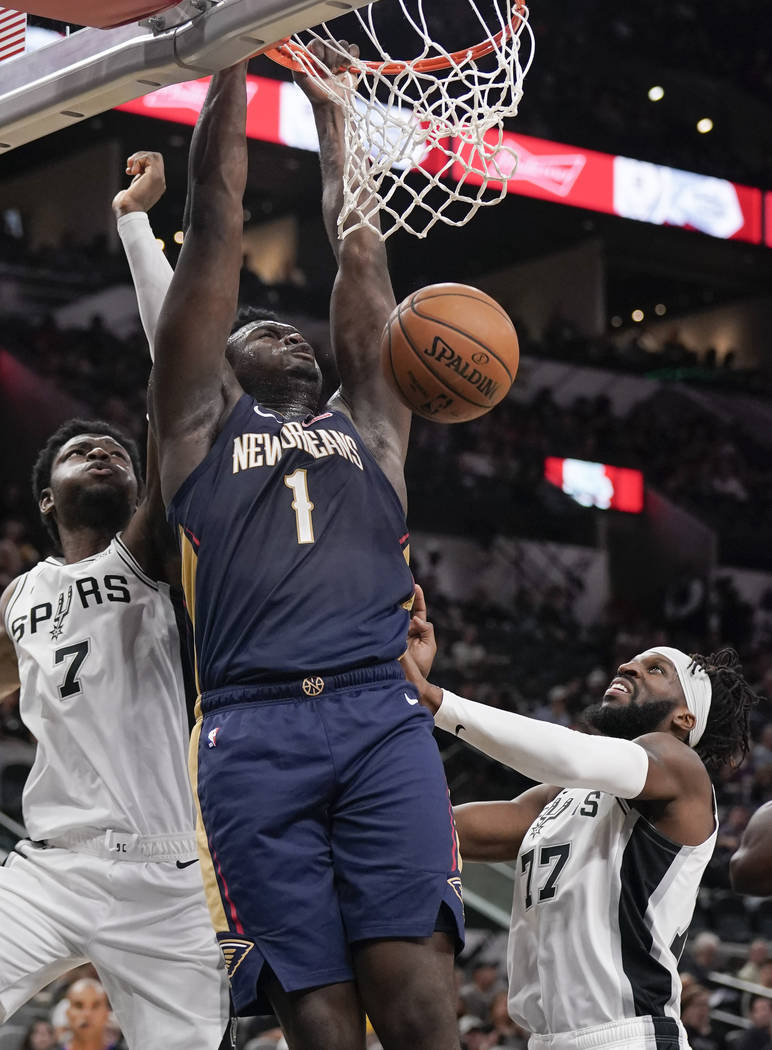 New Orleans Pelicans' Zion Williamson (1) dunks as he is defended by San Antonio Spurs' Chimezi ...