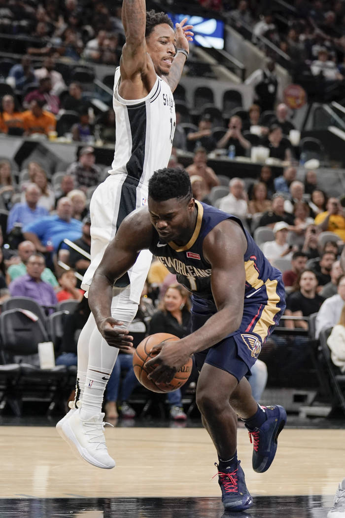 New Orleans Pelicans' Zion Williamson, right, falls as he tangles with San Antonio Spurs' DeMar ...