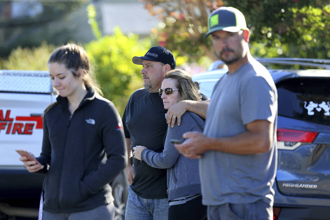 Brandon and Jessica Bayer, waiting for news of their son Andrew, 17, stand with student Jackely ...