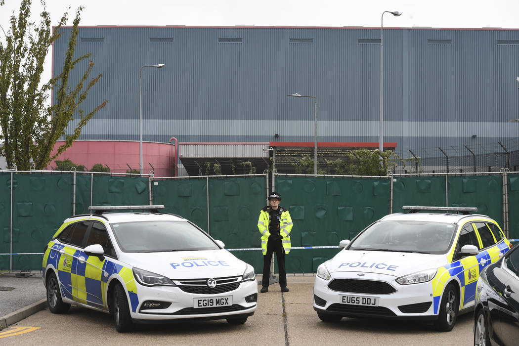 Police officers block the road near the scene where a truck was found to contain a large number ...