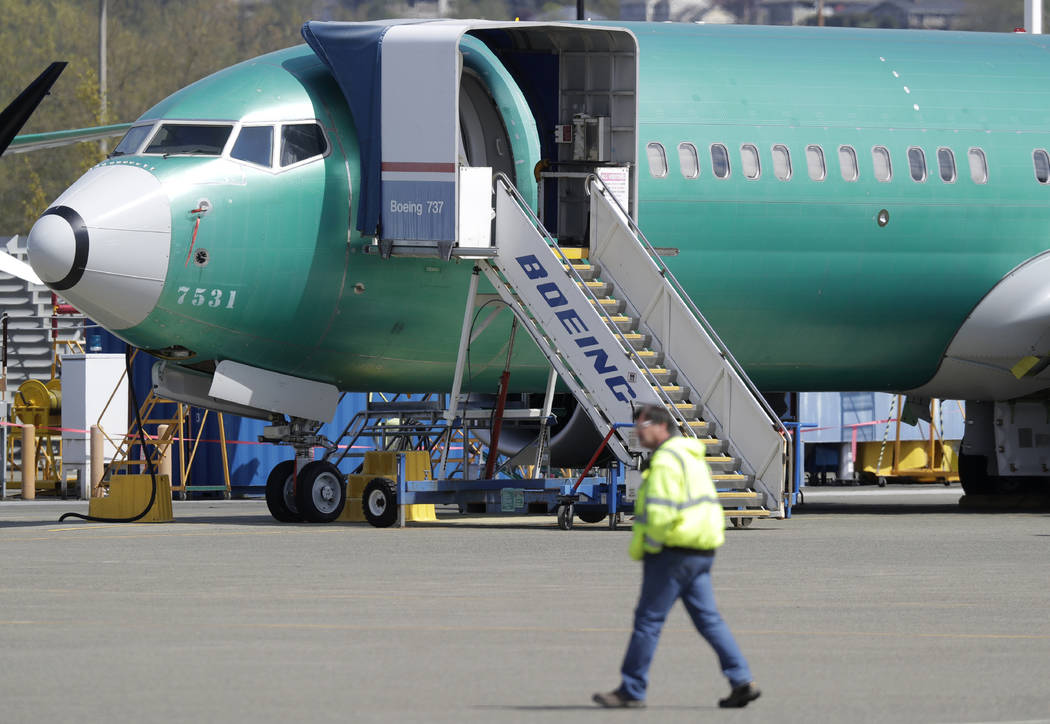 FILE - In this April 26, 2019, file photo a worker walks past a Boeing 737 MAX 8 airplane being ...