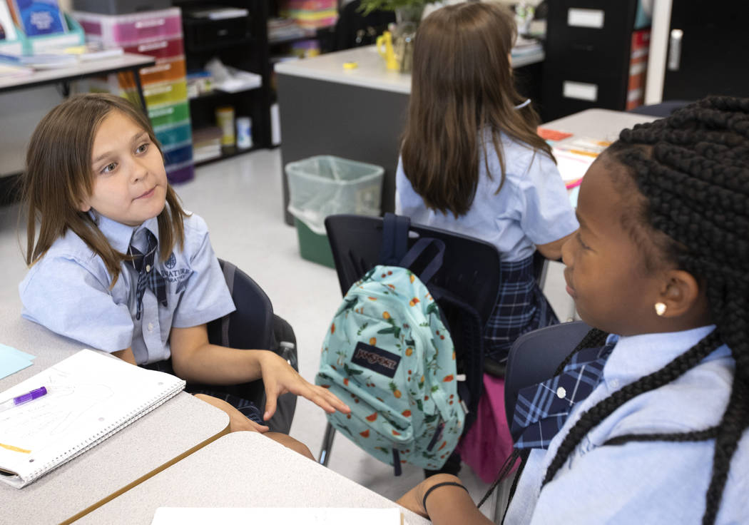 Fourth grader Aurora Bowers, 10, uses adjectives to describe dogs as part of a grammar exercise ...