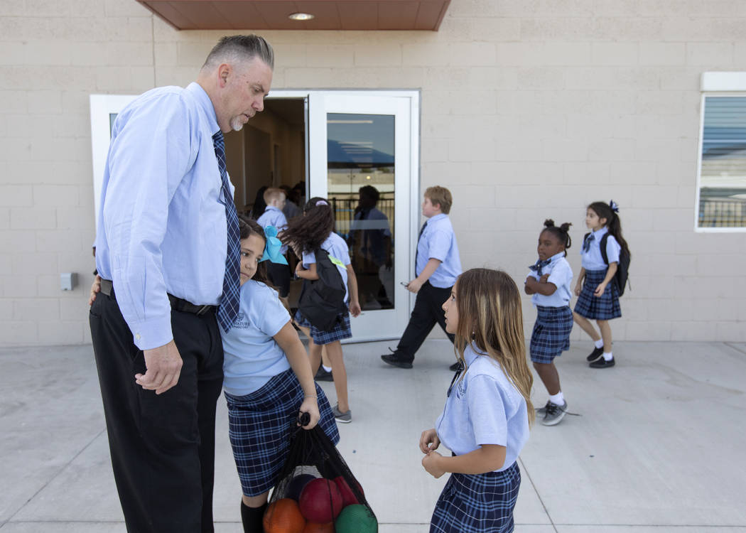 Carey Roybal-Benson, principal of Signature Preparatory, accepts a hug from third grader Paisle ...