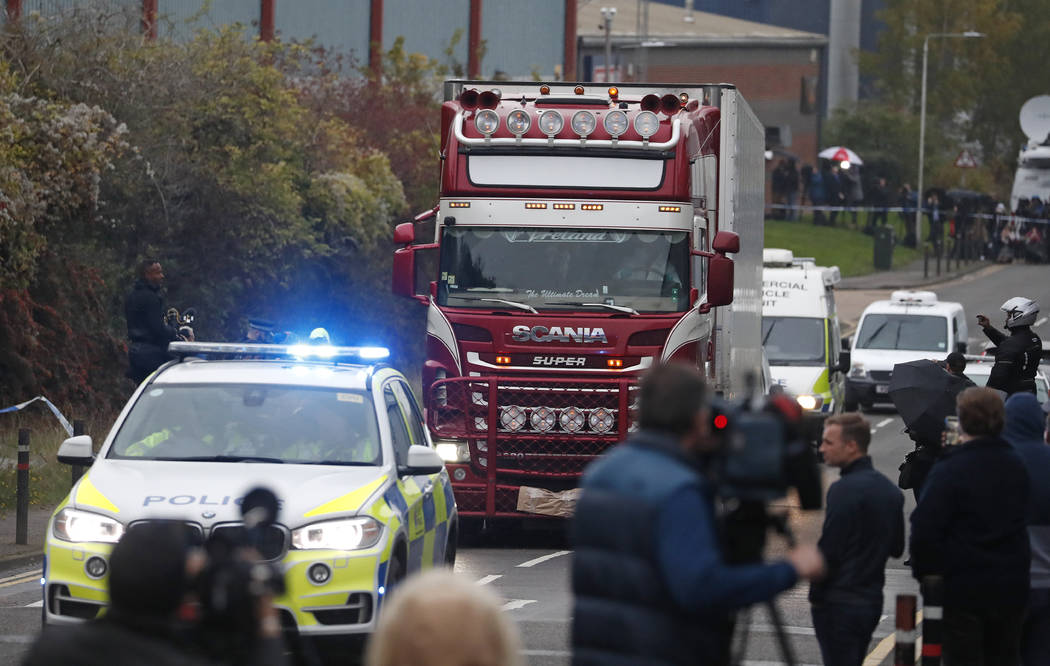 Police escort the truck, that was found to contain a large number of dead bodies, as they move ...