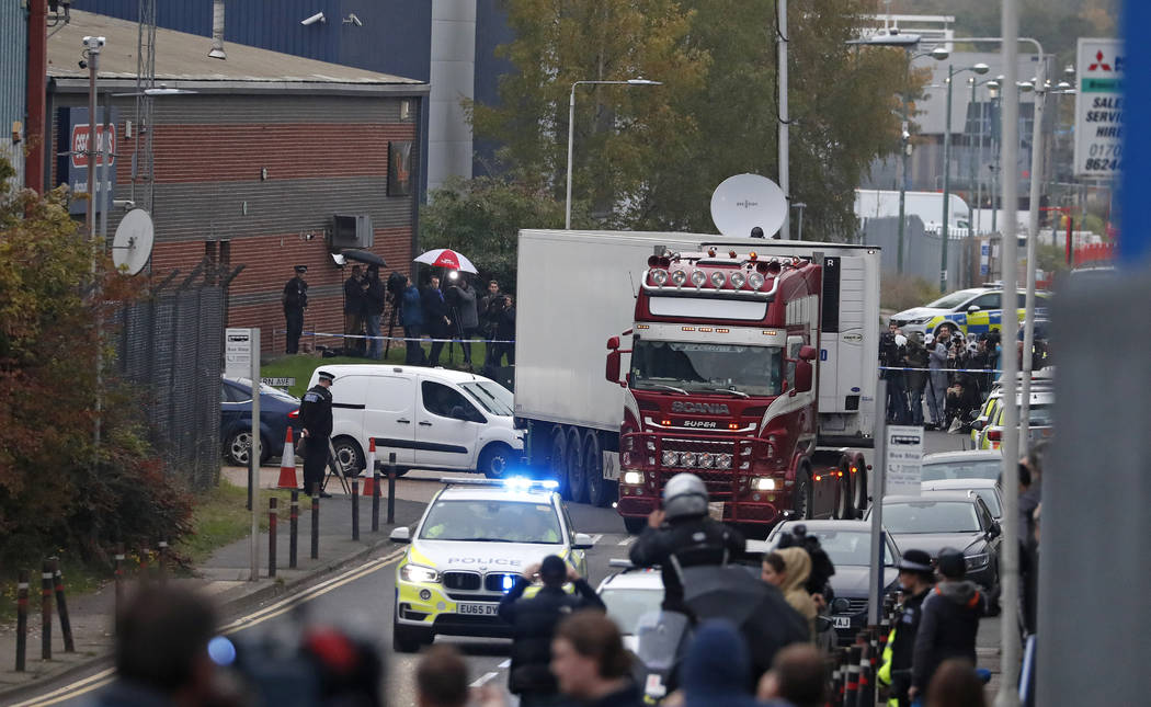 Police escort the truck, that was found to contain a large number of dead bodies, as they move ...