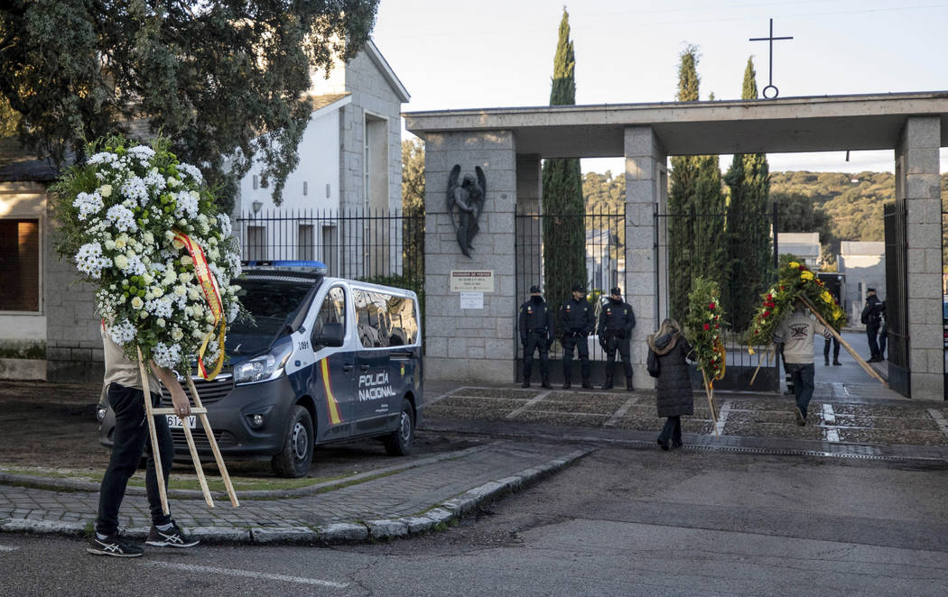 People carry wreath of flowers at Mingorrubio's cemetery, outskirts of Madrid, Thursday, Oct. 2 ...