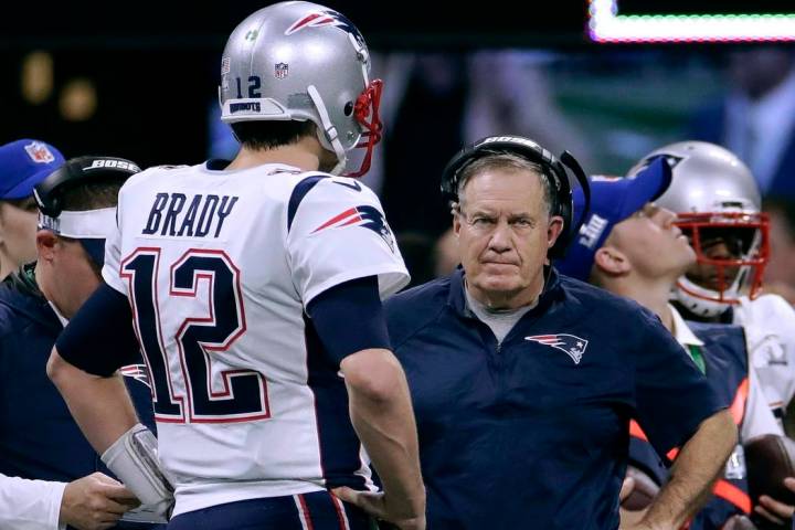 New England Patriots' Tom Brady, left, talks with head coach Bill Belichick during the first ha ...