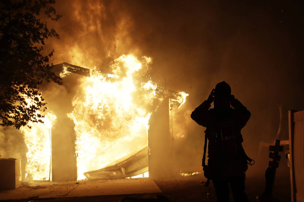 A firefighter prepares to fight a wildfire as it overtakes a home Thursday, Oct. 24, 2019, in S ...