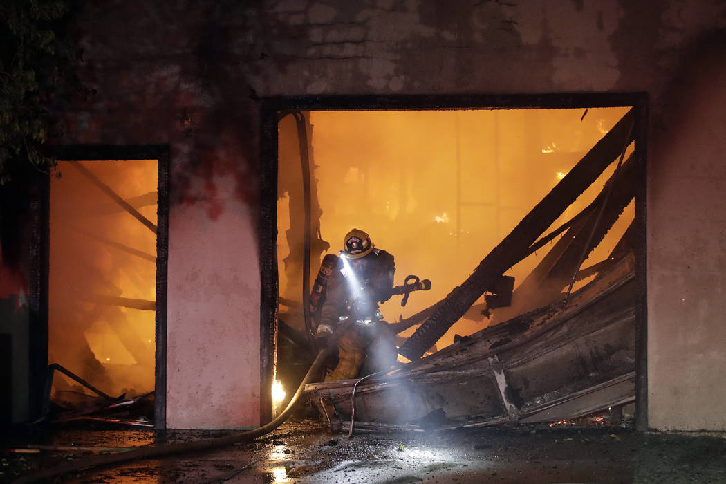 A firefighter works the scene of a wildfire-ravaged home Thursday, Oct. 24, 2019, in Santa Clar ...