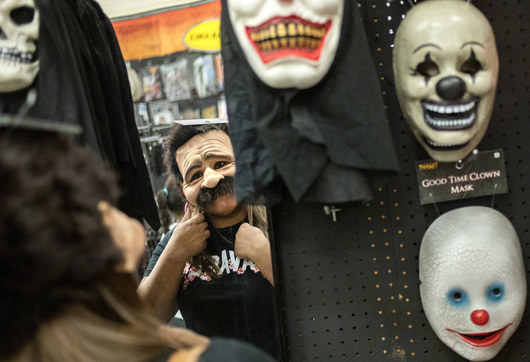 Laura Silva of St. George, Utah tries on a mask for her upcoming Halloween costume on Wednesday ...