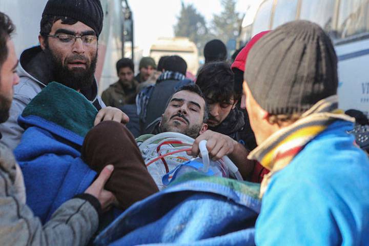 An injured Syrian arrives at a refugee camp in Rashidin, near Idlib, Syria, after was evacuated ...