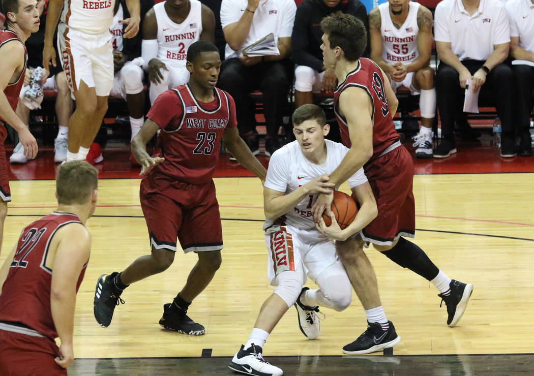 UNLV's guard Trey Hurlburt (12) surrounded by West Coast Baptist guards Joseph Lowe (23) and Sa ...