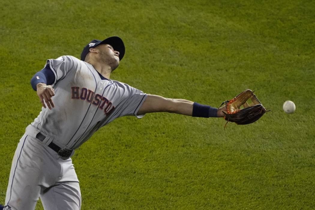 Houston Astros' Carlos Correa can't catch a ball hit by Washington Nationals' Adam Eaton during ...