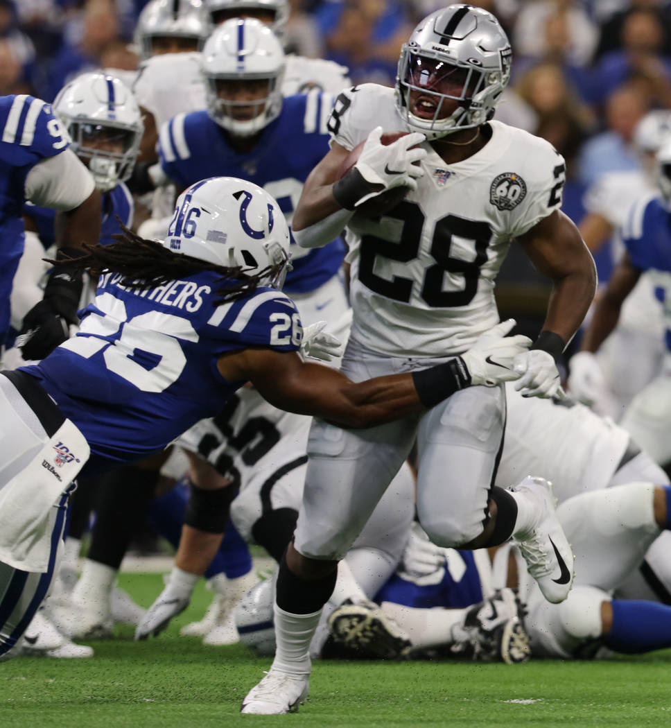 Oakland Raiders running back Josh Jacobs (28) runs past Indianapolis Colts strong safety Clayto ...