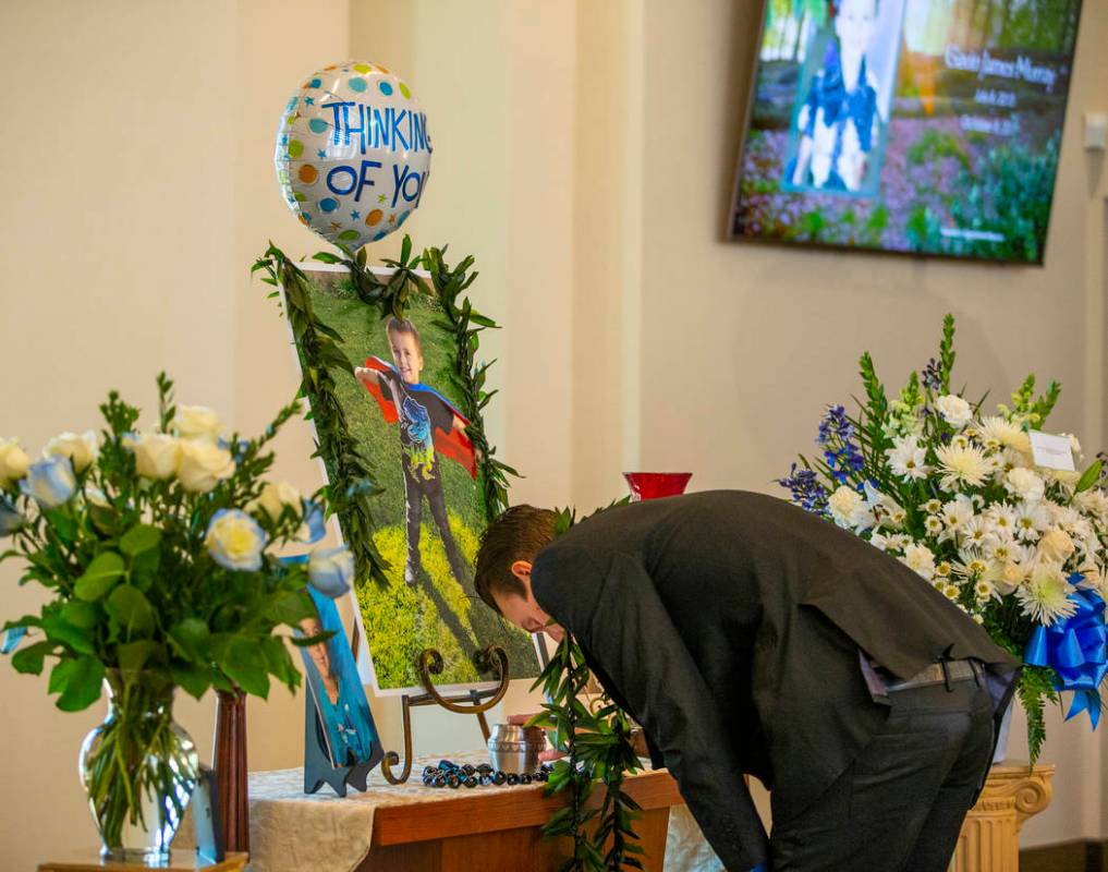 Sean Murray, center, weeps and touches the urn of his son Gavin Murray, 6, during Gavin's fune ...