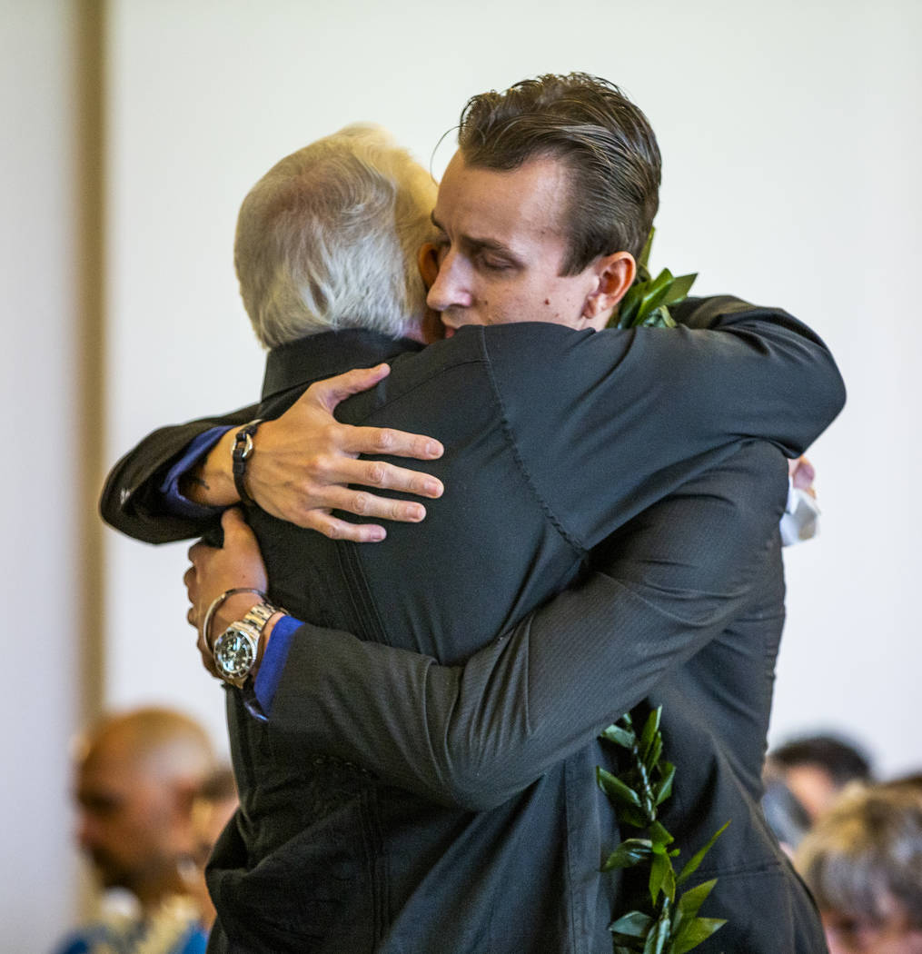 Sean Murray, right, is hugged by his father, Gordon Murray, during a funeral service for his s ...