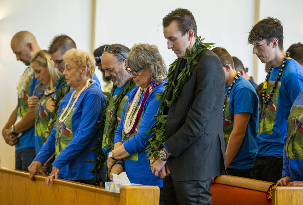Sean Murray, center, prays next to grandparents Kathleen and Chuck Wheeler and many others duri ...