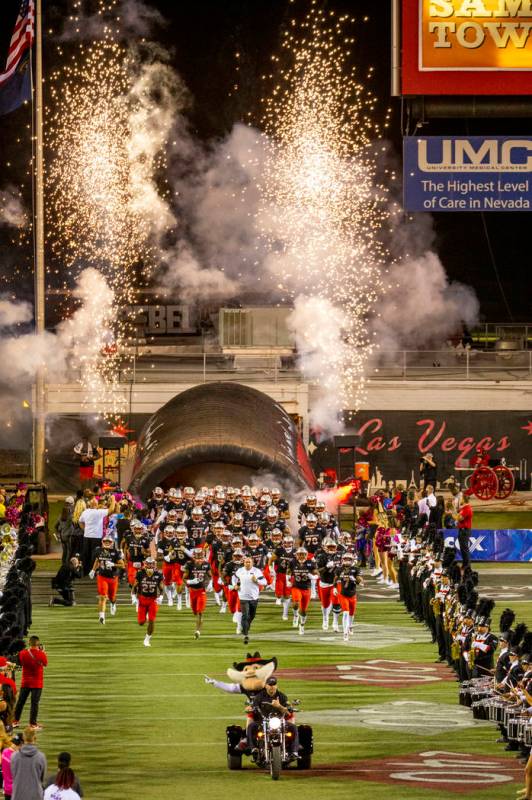 UNLV players and coaches take the field versus San Diego State for their football game at Sam B ...