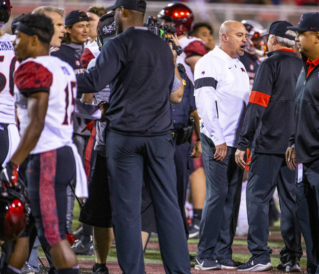 UNLV Rebels head coach Tony Sanchez chats with San Diego State Aztecs head coach Rocky Long at ...