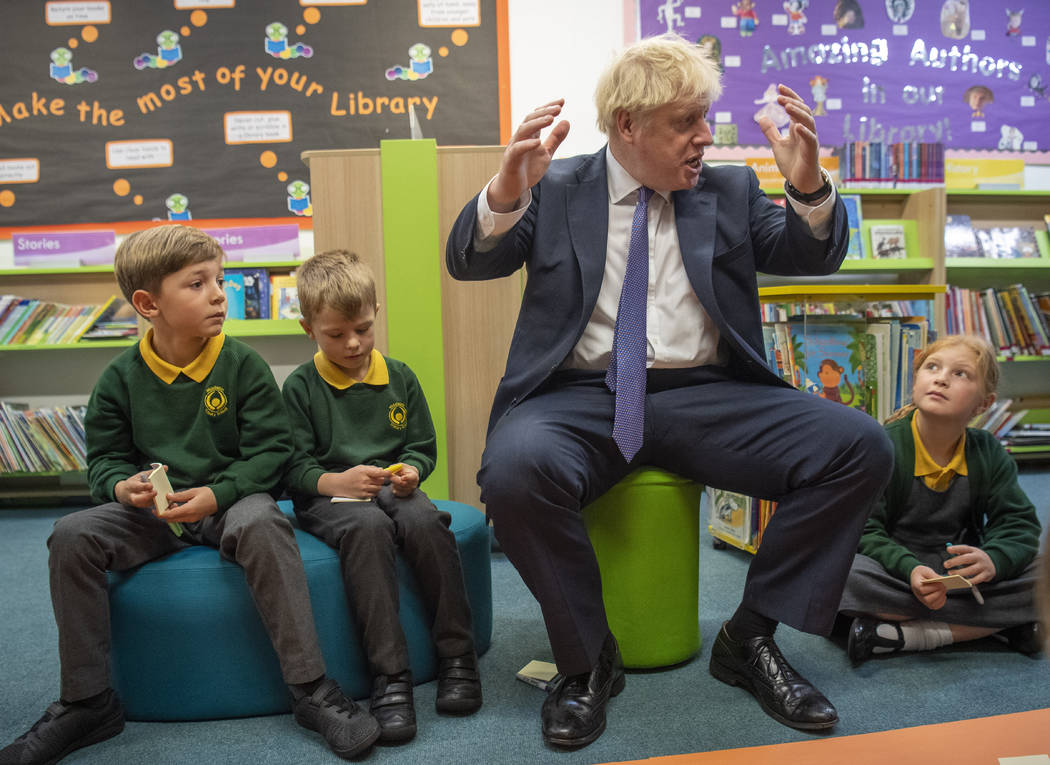 Britain's Prime Minister Boris Johnson, right, reacts with pupils during a visit to Middleton P ...