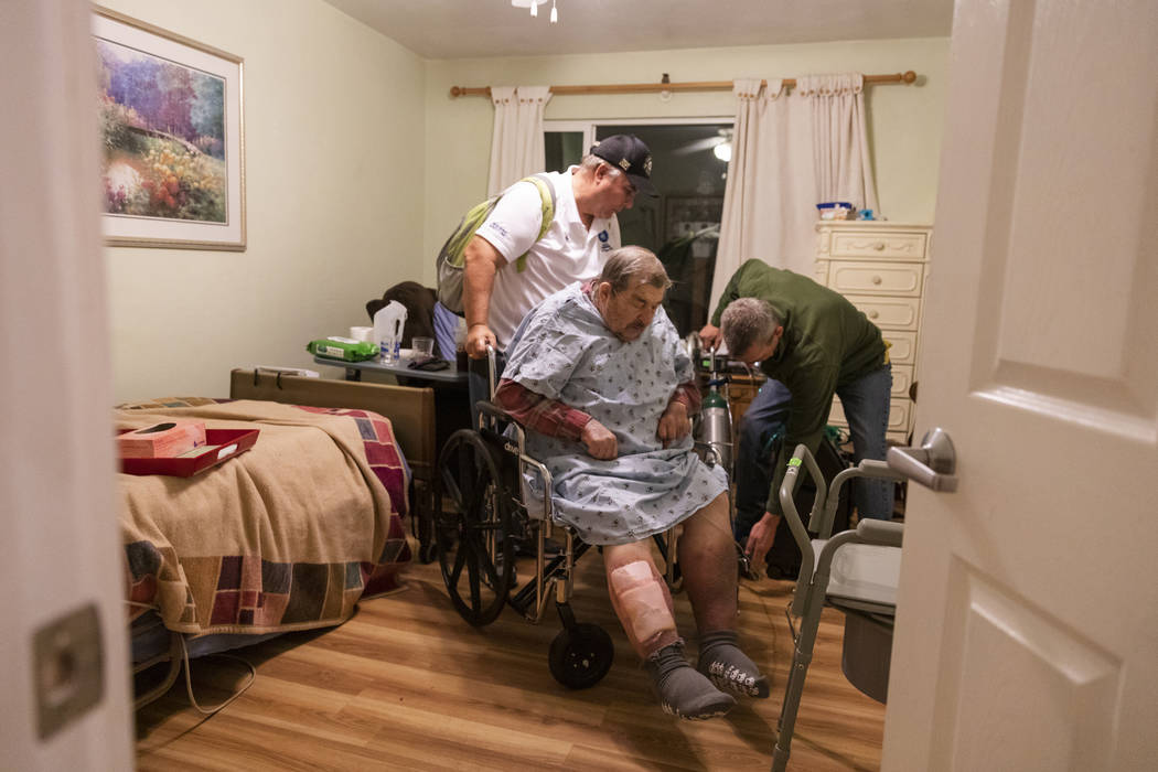 Henry Provencher, center, 87, receives help from his son Henry Provencher, left, and Eric Moess ...