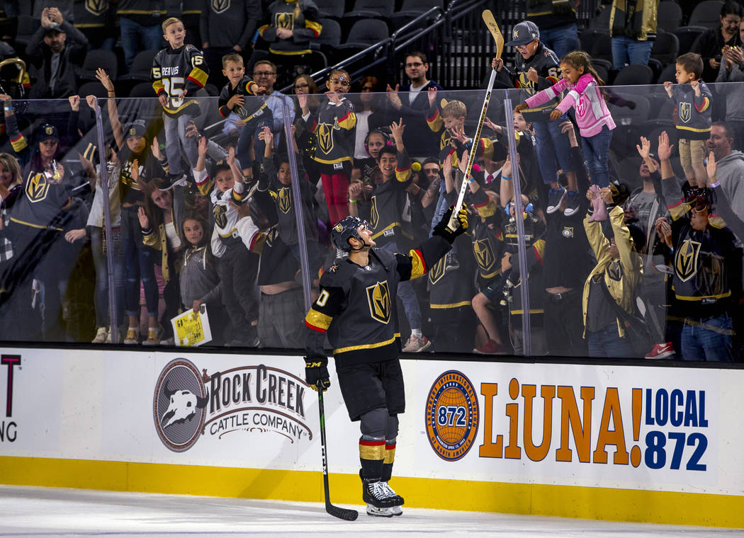 Vegas Golden Knights center Nicolas Roy (10) gives away his stick to a lucky fan after scoring ...