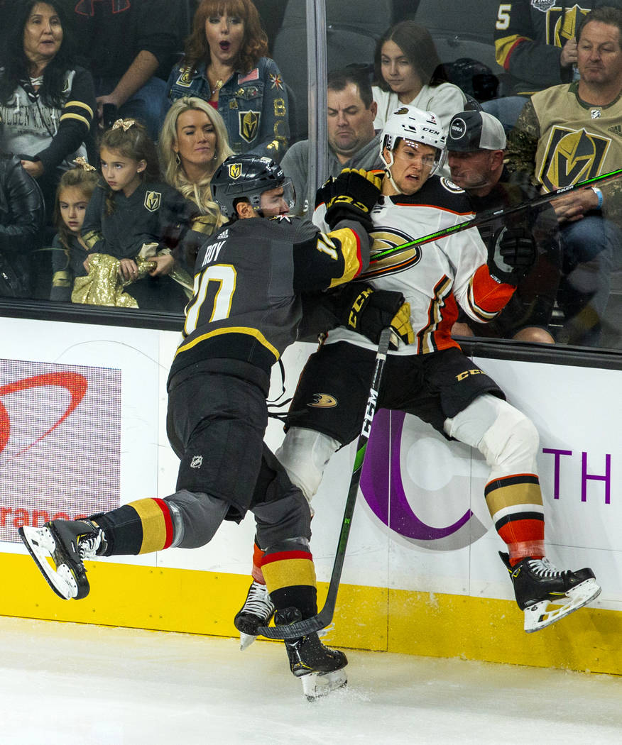 Vegas Golden Knights center Nicolas Roy (10) checks Anaheim Ducks defenseman Brendan Guhle (2) ...