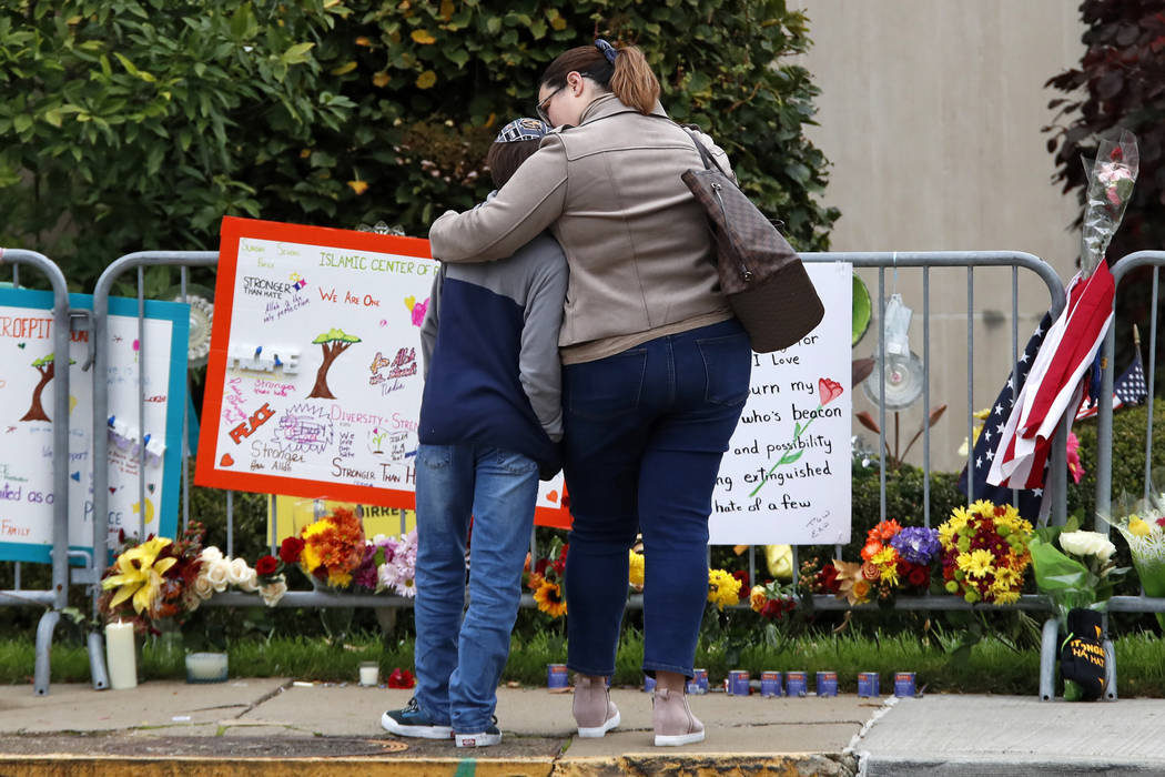 A mother hugs her son in front of a memorial at the Tree of Life synagogue in Pittsburgh on Sun ...