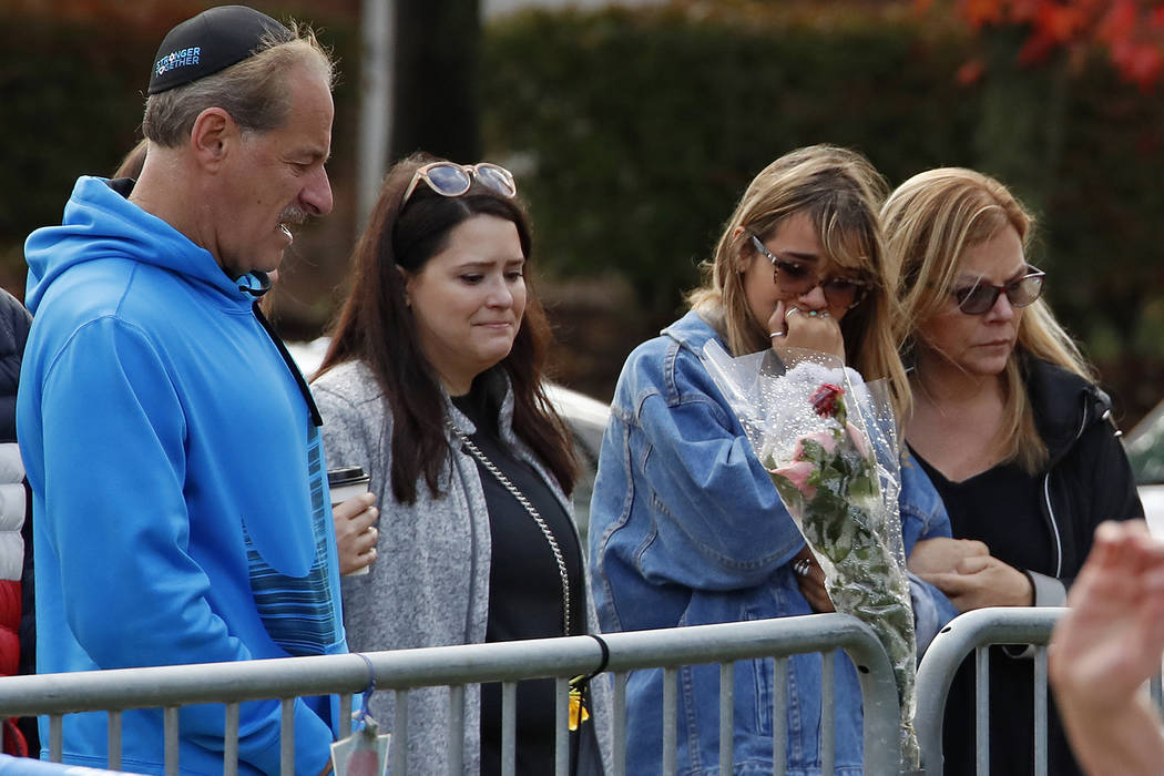 People gather in front of a fence that surrounds the Tree of Life synagogue in Pittsburgh on Su ...
