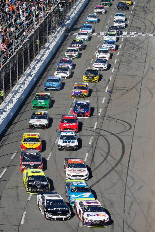 Denny Hamlin (11) leads the field at the start of a NASCAR Cup Series race at Martinsville Spee ...