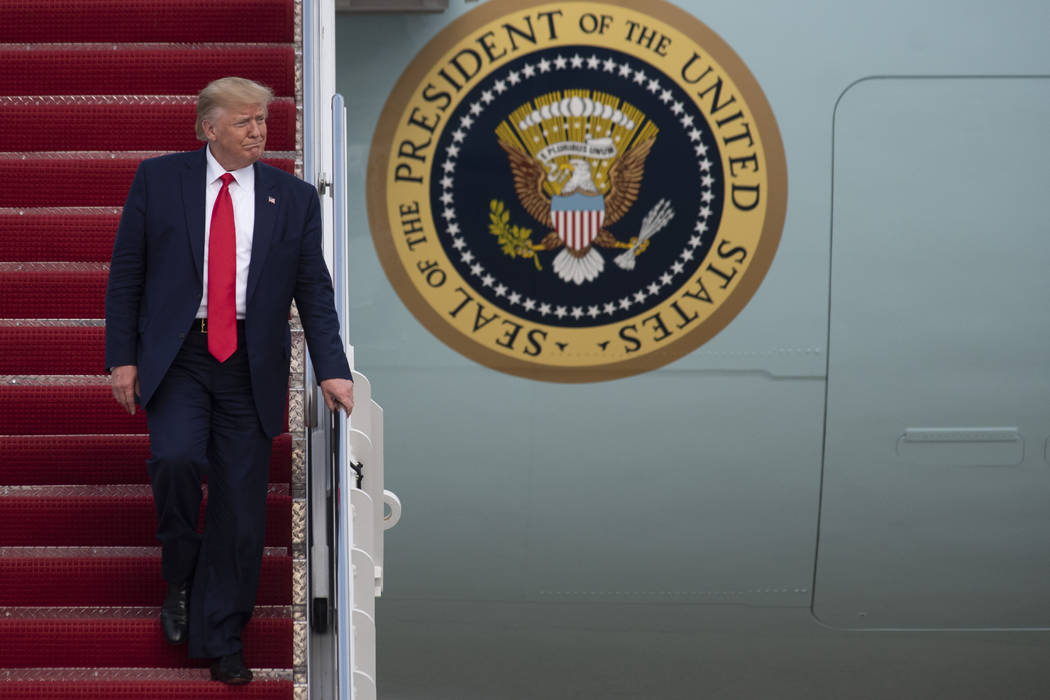 President Donald Trump walks from Air Force One at Andrews Air Force Base, Md., following a tri ...