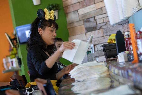Mikayla Cabildo of Chicago, dressed as Minnie Mouse, rolls silverware at Rise & Shine in the So ...