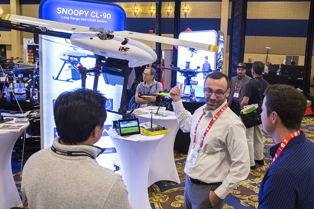 Eric Torres, middle, with Innoflight Technology, discusses the Snoopy CL-90 drone during the Co ...