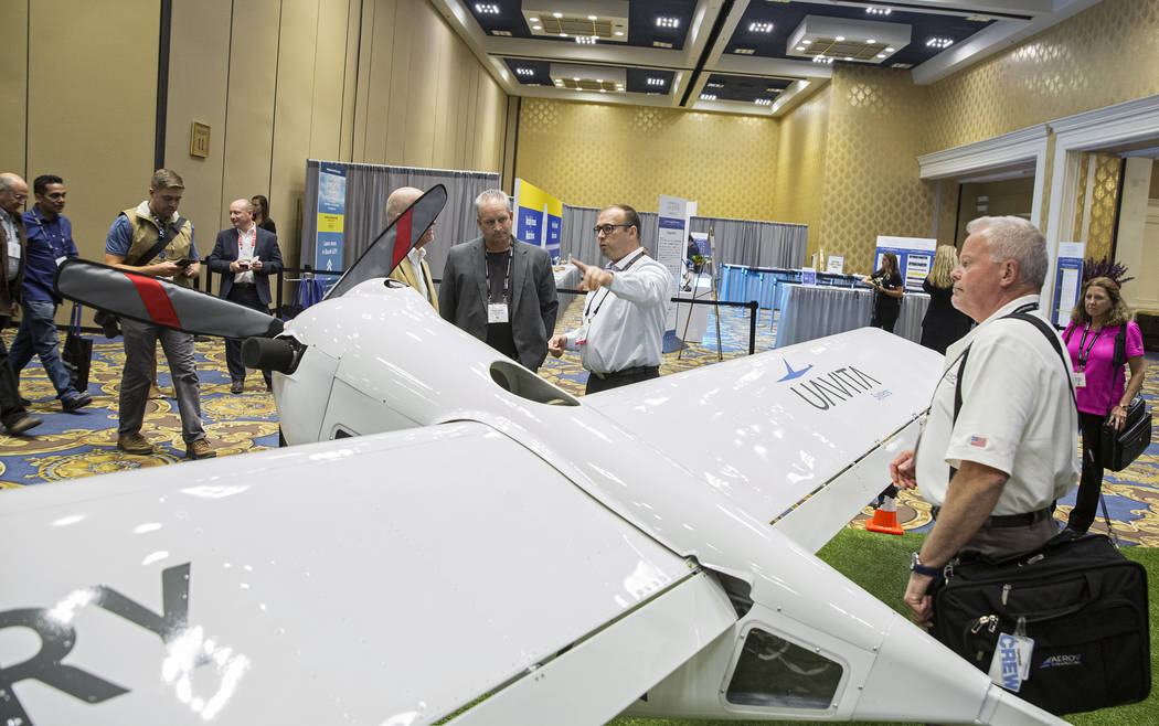 Yuri Pederiy, third from right, a mission specialist with Uavita Systems Sarl, points out featu ...