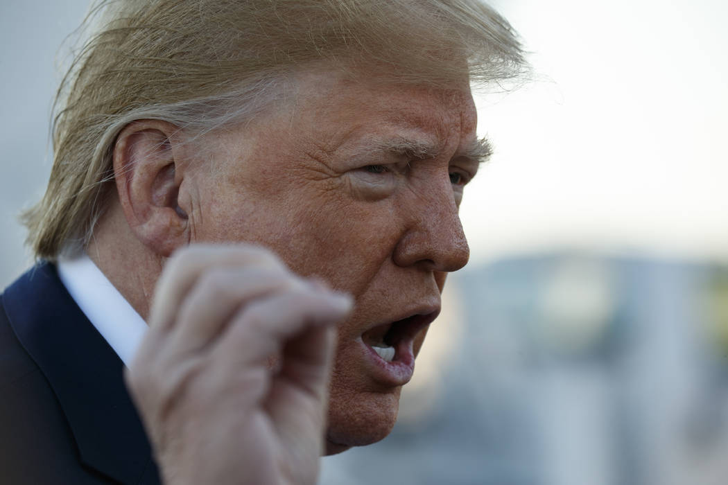 President Donald Trump talks to reporters before boarding Air Force One for a trip to Chicago t ...