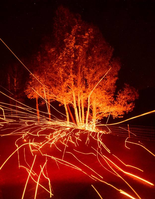 Strong winds send embers flying across Ida Clayton Rd. as the Kincade Fire burns in Calistoga, ...