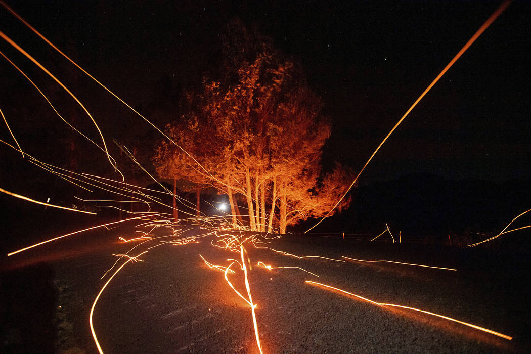 Strong winds send embers flying across Ida Clayton Rd. as the Kincade Fire burns in Calistoga, ...