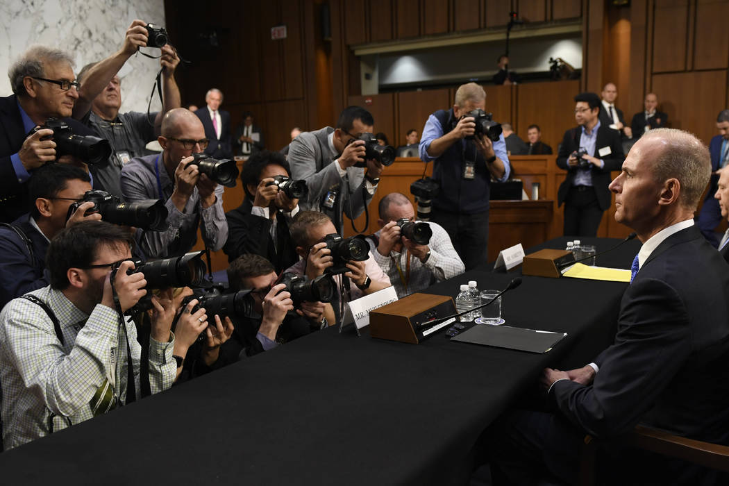 Boeing Company President and Chief Executive Officer Dennis Muilenburg, right, is surrounded by ...