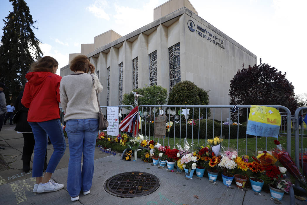 Passersby stop to pay respect outside the Tree of Life synagogue in Pittsburgh on Sunday, Oct. ...