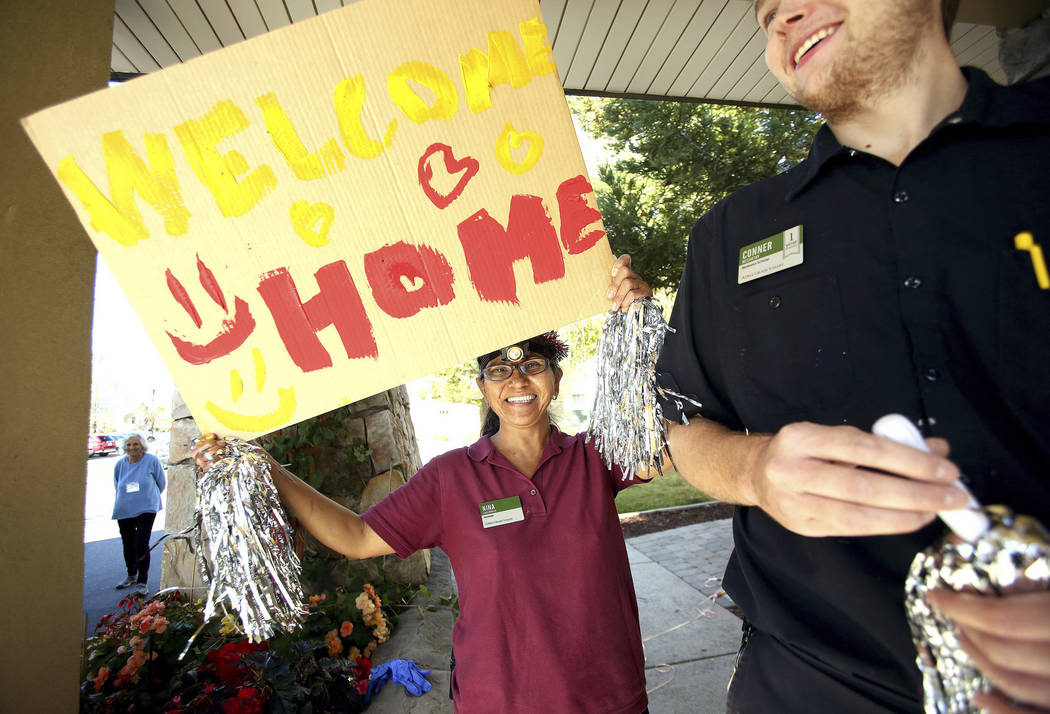 Atria Grass Valley housekeeper Nina Underwood dances and shakes a sign welcoming the Atria assi ...