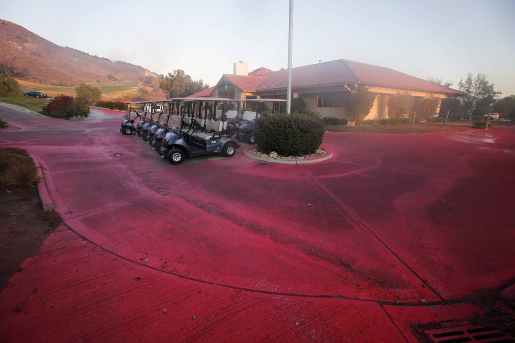 Fire retardant covers the driveway of a golf club in Simi Valley, Calif., Wednesday, Oct. 30, 2 ...