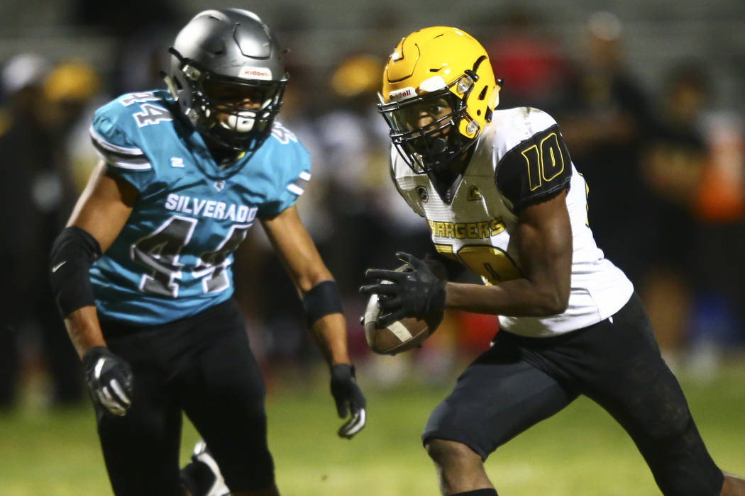 Clark's Dillan Lavender (10) runs the ball against Silverado's Chris Federico (44) during the f ...