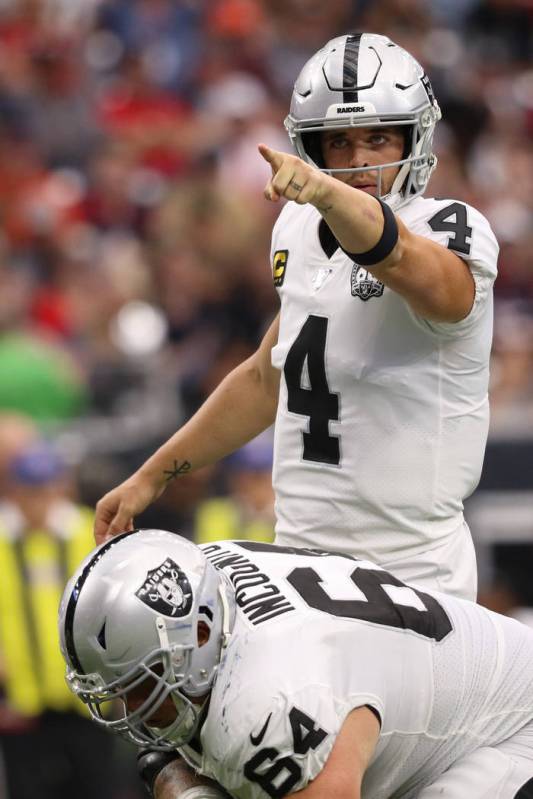 Oakland Raiders quarterback Derek Carr (4) points to a defender from the line of scrimmage as o ...